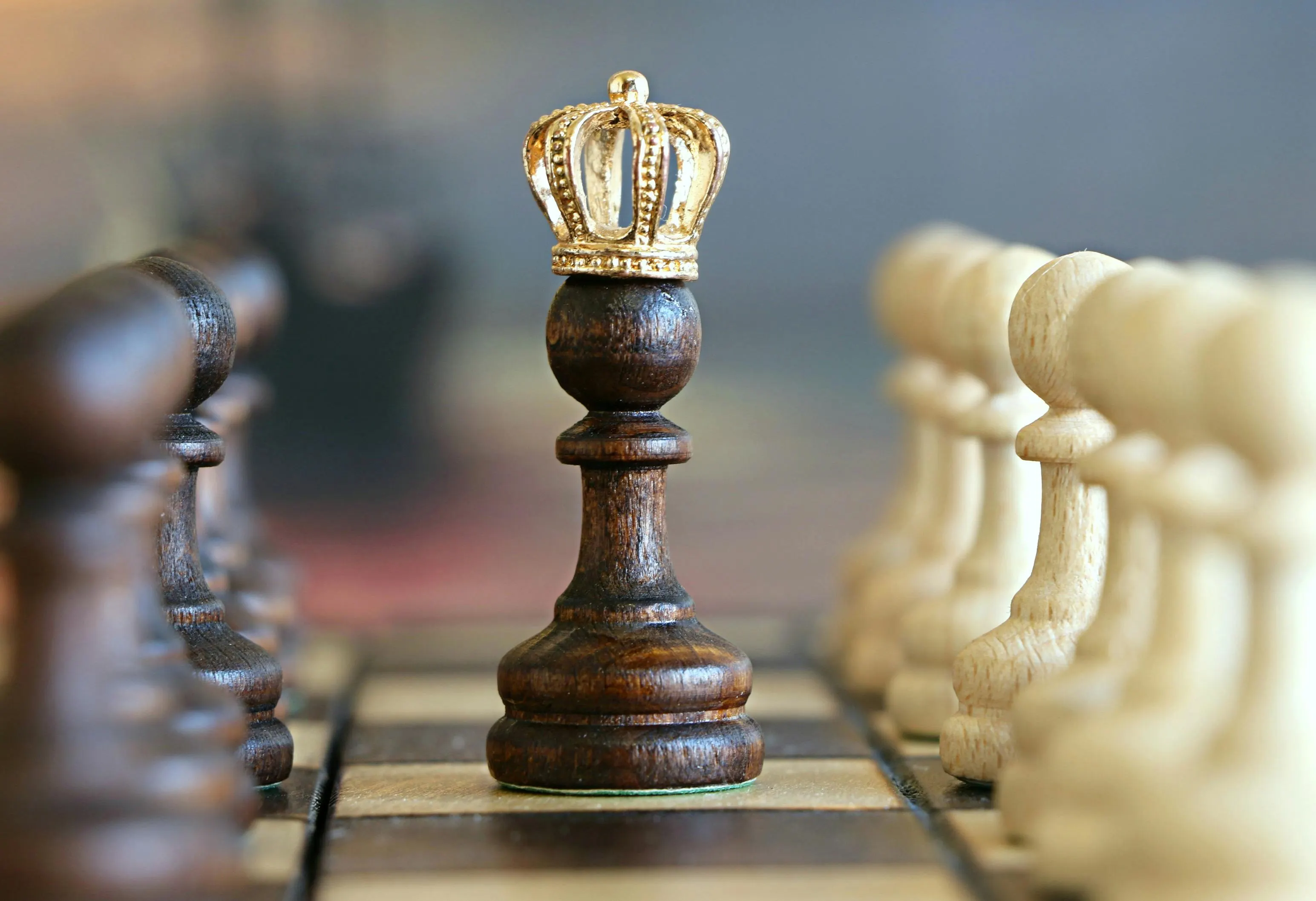 Two chess pieces, a king and a queen, on a board, symbolizing strategic decision-making in talent management.
