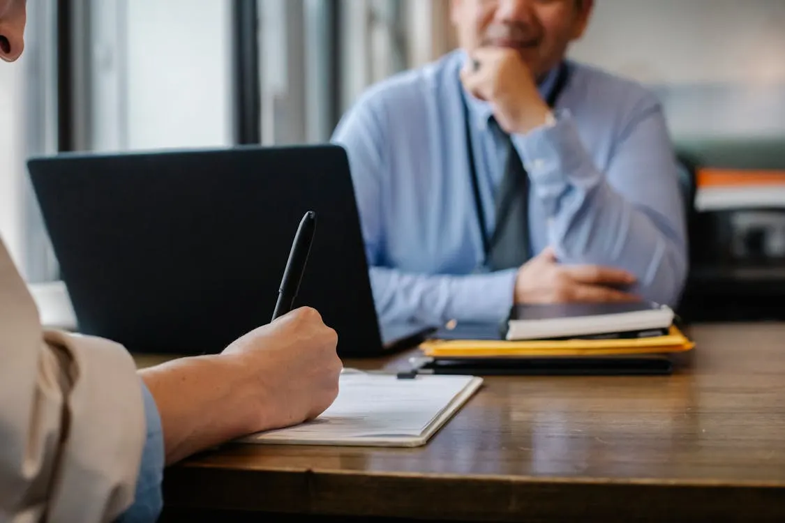 Employment Contract Review via EOR A person reviews their employment contract and benefits on a laptop, with an expression of security and satisfaction.