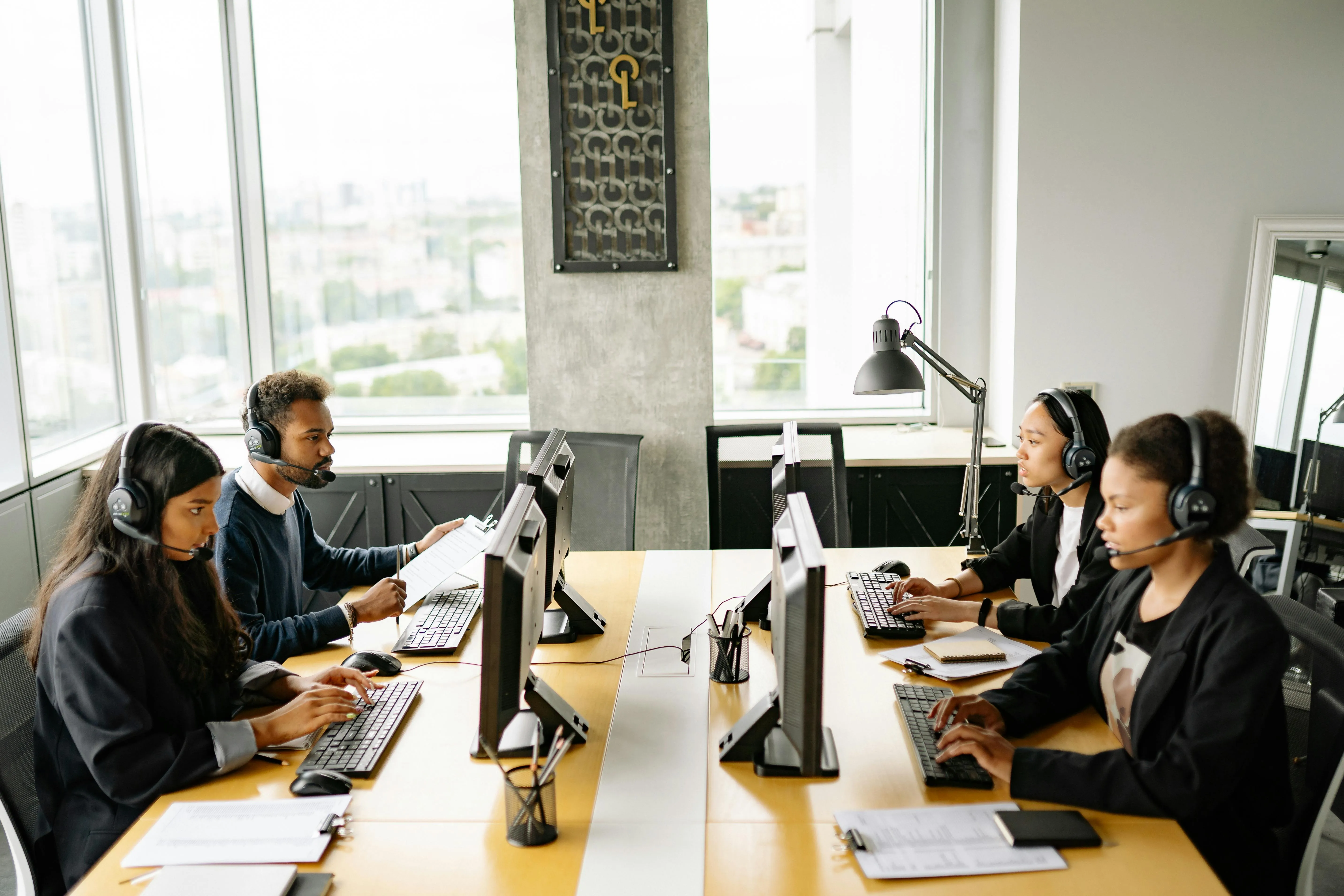 An HR leader and her team analyzing hiring metrics dashboards on a large screen in a modern office.